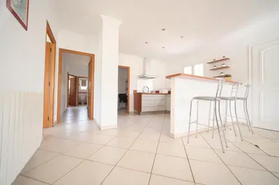 a white kitchen with a counter and stools at La ferme in Moltifao