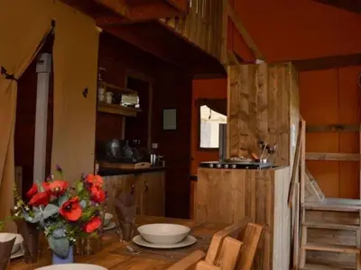a kitchen with a wooden table with flowers on it at Tente Lodge pour 8 avec Terrasse à Sartène - API-1-52-1656 in Sartène