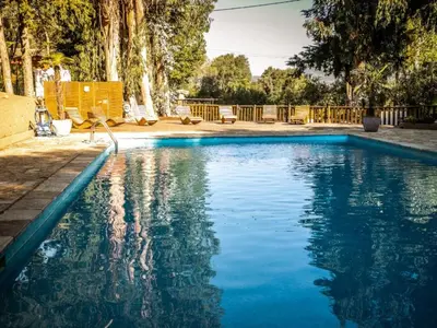 a swimming pool with blue water in a yard at Tente Lodge pour 8 avec Terrasse à Sartène - API-1-52-1656 in Sartène