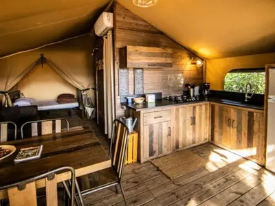 a kitchen and dining room with a table in a tent at Tente Lodge avec Terrasse - 5 Pers, 2 Ch, Réfrigérateur - API-1-52-1658 in Sartène