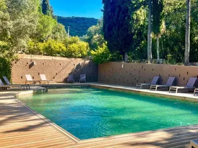 a swimming pool with chairs and trees and a wall at Tente Lodge avec Terrasse - 5 Pers, 2 Ch, Réfrigérateur - API-1-52-1658 in Sartène