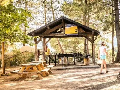 a woman standing in front of a picnic shelter with a piano at Mobil Home 3 Chambres avec Terrasse - Pour 6 Personnes - API-1-52-1659 in Sartène