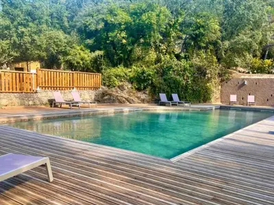 a swimming pool with chairs on a wooden deck at Mobil Home 3 Chambres avec Terrasse - Pour 6 Personnes - API-1-52-1659 in Sartène