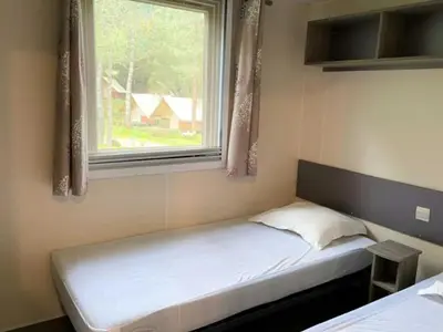 a small bed in a room with a window at Mobil-home confortable avec terrasse pour 4 pers. - API-1-52-1661 in Sartène