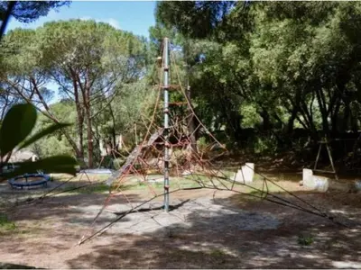 a park with a bench and trees and a stone wall at Mobil-home confortable avec terrasse pour 4 pers. - API-1-52-1661 in Sartène