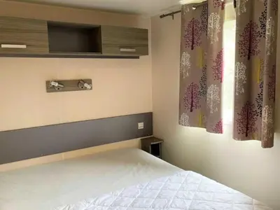 a bedroom with a bed and a tv on the wall at Mobil-home confortable avec terrasse pour 4 pers. - API-1-52-1661 in Sartène