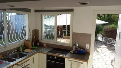 a kitchen with two windows and a sink and a stove at CORSE bord de plage SANT AMBROGGIO