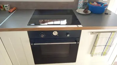a black oven in a kitchen with a counter at CORSE bord de plage SANT AMBROGGIO