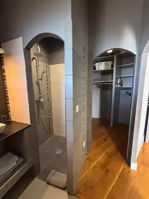 a bathroom with a walk in shower and a walk in closet at VILLA Cala D'orzu in Coti-Chiavari