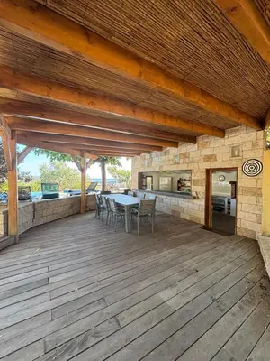a wooden deck with a table and chairs on it at VILLA Cala D'orzu in Coti-Chiavari