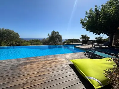 a large swimming pool on a wooden deck at VILLA Cala D'orzu in Coti-Chiavari