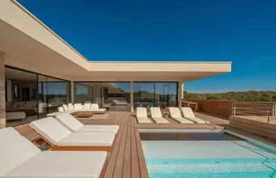 a house with a swimming pool and white chairs at Villa CASATANGO in Zonza