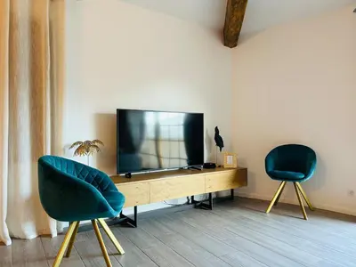 a living room with two chairs and a television at Charmante villa dans un petit coin de Paradis in Propriano