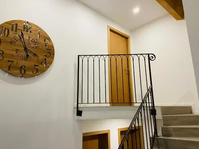 a large clock on a wall next to a staircase at Charmante villa dans un petit coin de Paradis in Propriano