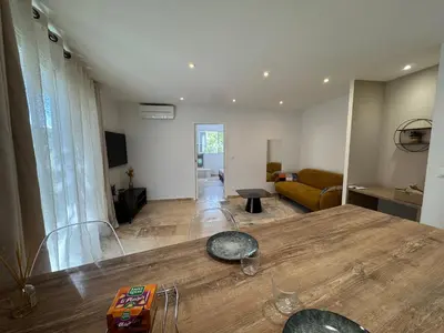 a living room with a table and a couch at SUPERBE T2 moderne - ENTREE DE VILLE - PARKING PRIVE in Ajaccio