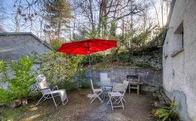 a table and chairs with a red umbrella at Casa Lisandru