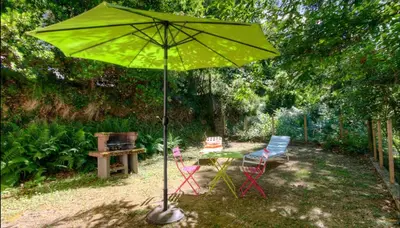 a table and chairs under an umbrella in a yard at Casa Lisandru