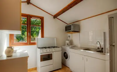 a kitchen with a stove and a washing machine at Casa Lisandru