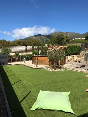 a green pillow laying on a lawn at A Murella - maison de vacances à Oletta en Corse in Oletta