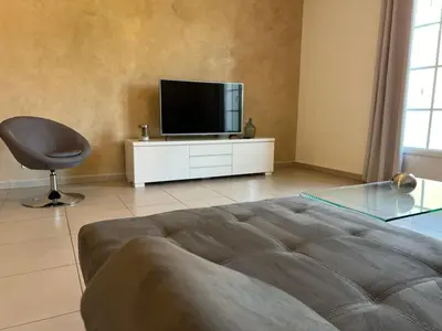 a living room with a television and a chair at A Murella - maison de vacances à Oletta en Corse in Oletta