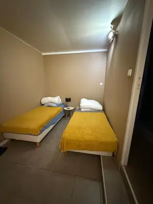 two beds in a small room with yellow sheets at u limone in Porticcio