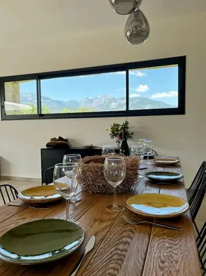 a table with glasses and plates on top of it at Granite Villa Between Porto-Vecchio And Bonifacio in Figari