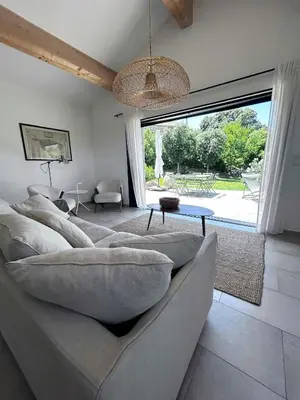 a living room with a couch and a large window at Granite Villa Between Porto-Vecchio And Bonifacio in Figari