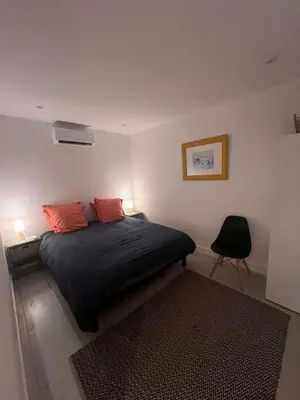 a bedroom with a bed with two orange pillows at Le magasin in Conca