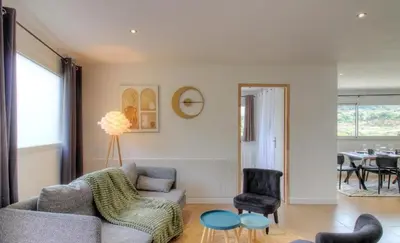 a living room with a couch and a table at Appartement avec grande terrasse in Viggianello