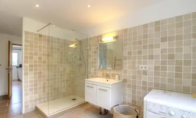 a bathroom with a sink and a shower with a mirror at Appartement avec grande terrasse in Viggianello