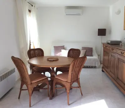 a dining room with a table and chairs and a bed at Maison avec piscine sans voisinage à 4km de la mer in Canale-di-Verde