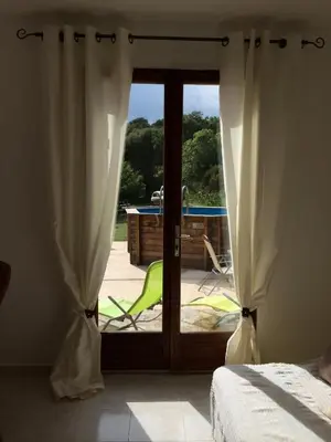 a bedroom with a sliding glass door to a patio at Maison avec piscine sans voisinage à 4km de la mer in Canale-di-Verde