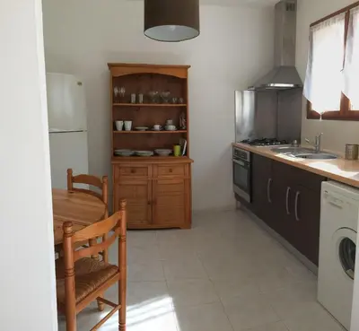 a kitchen with a table and a chair and a sink at Maison avec piscine sans voisinage à 4km de la mer in Canale-di-Verde