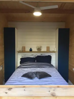 a cat laying on a bed in a room at Casa Di Legnu -T2 - Calme et bien situé in Appietto