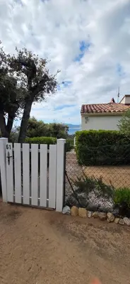 a white fence in front of a house at Maison vue mer Porticcio in Porticcio