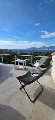 a chair and a table on a balcony at Maison vue mer Porticcio in Porticcio