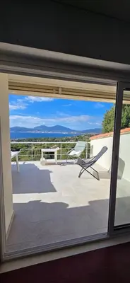 a view from a window of a patio with a chair at Maison vue mer Porticcio in Porticcio