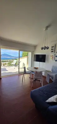a room with a bed and a table and a view at Maison vue mer Porticcio in Porticcio