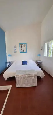 a bedroom with a large bed and two tables at Maison vue mer Porticcio in Porticcio