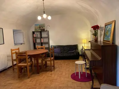 a living room with a table and a piano at Sartene - Corse du sud ouest in Sartène