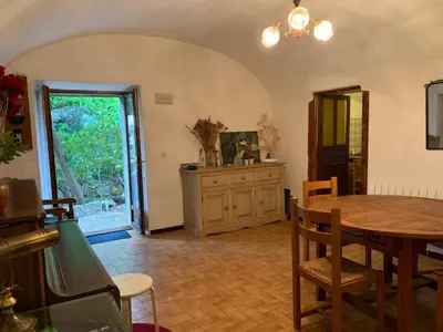 a dining room with a wooden table and a table and chairs at Sartene - Corse du sud ouest in Sartène