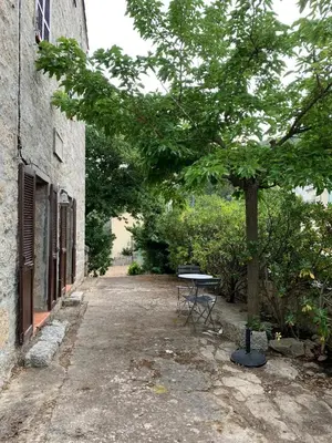a picnic table next to a tree next to a building at Sartene - Corse du sud ouest in Sartène
