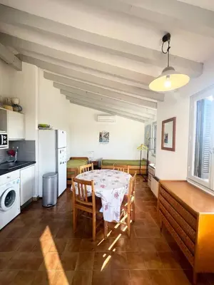 a kitchen and dining room with a table and chairs at Appartement au cœur de Porticcio in Porticcio