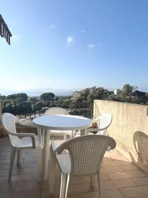 a white table and chairs sitting on a balcony at Appartement au cœur de Porticcio in Porticcio