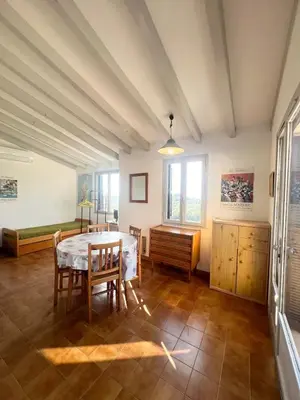 a dining room with a table and chairs at Appartement au cœur de Porticcio in Porticcio