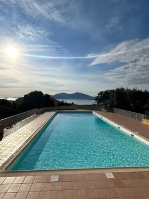 a large blue swimming pool on a building at Charmant studio au centre de Porticcio in Grosseto-Prugna