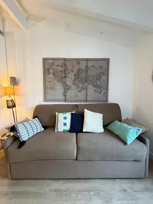 a couch with pillows on it in a living room at Charmant studio au centre de Porticcio in Grosseto-Prugna