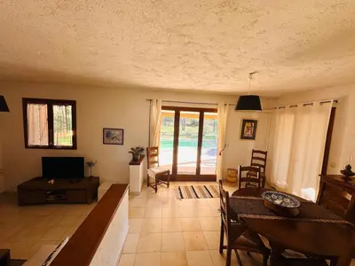 a living room with a table and a dining room at Charmante Villa Privée avec Piscine in Porto-Vecchio