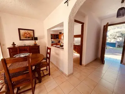 a dining room with a table and a kitchen at Charmante Villa Privée avec Piscine in Porto-Vecchio