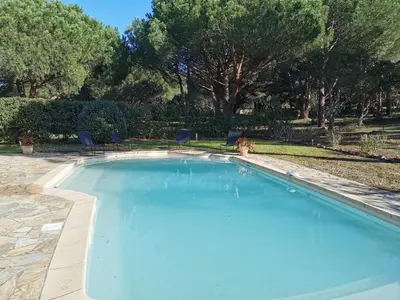 a large blue swimming pool in a yard at Charmante Villa Privée avec Piscine in Porto-Vecchio